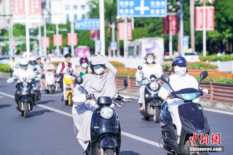 7月12日，廣西南寧，市民“捂裝”騎行。當(dāng)日，南寧市氣象臺繼續(xù)發(fā)布高溫黃色預(yù)警信號。 中新社記者 陳冠言 攝