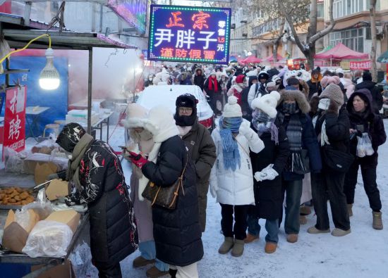 在哈爾濱紅專街早市，顧客們排起長隊購買油炸糕（1月22日攝）。新華社記者 王毓國 攝