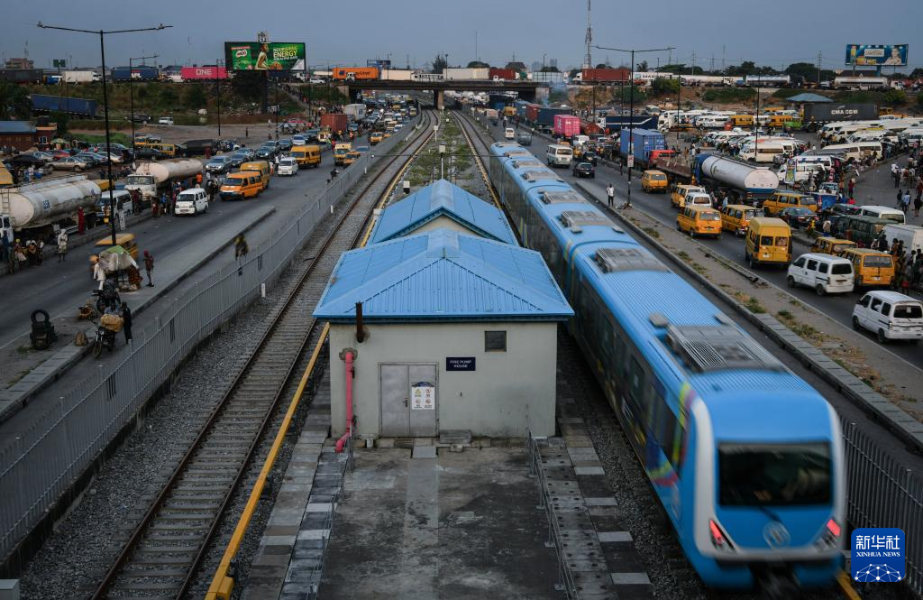 3月4日，在尼日利亞拉各斯，一列輕軌藍(lán)線列車行駛至公路交通擁堵路段附近。新華社記者 韓旭 攝