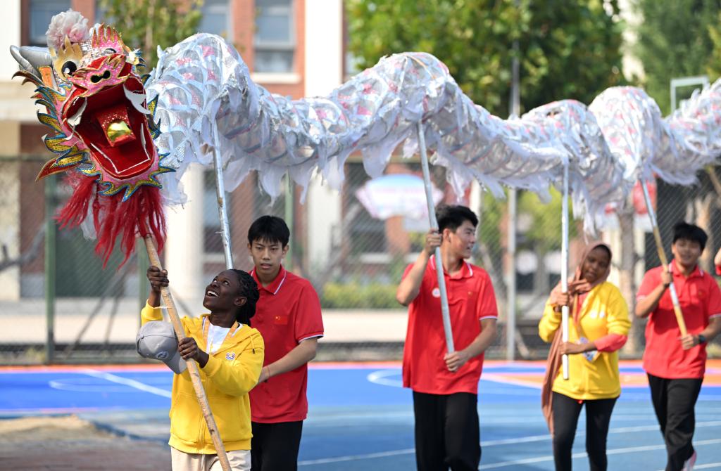 10月25日，“汉语桥”选手在天津霍元甲学校的操场上学习舞龙。新华社记者 李然 摄