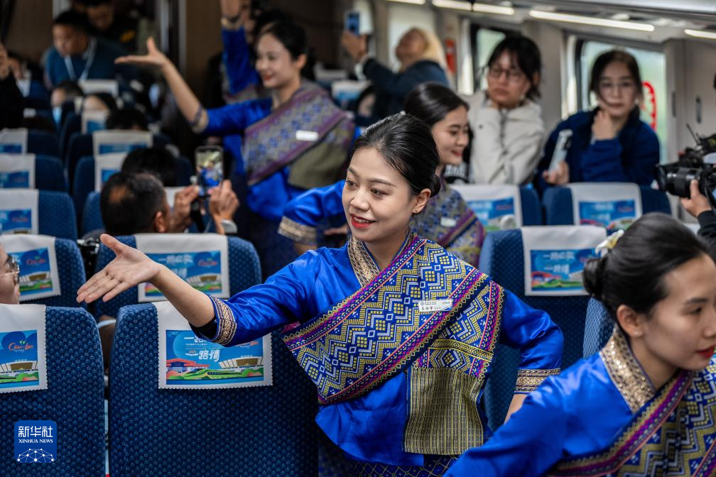 1月14日，中國鐵路昆明局“金花列車員”在D87次中老鐵路國際旅客列車上表演節(jié)目。新華社記者 胡超 攝