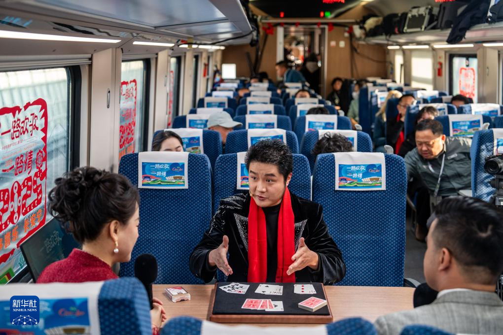 1月14日，魔術(shù)師戚原睿（中）在D87次中老鐵路國際旅客列車上表演近景魔術(shù)。新華社記者 胡超 攝