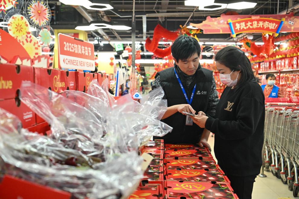 2024年12月26日，在天津市西青區(qū)一家大型商超，工作人員指導(dǎo)顧客線上下單智利車?yán)遄?。新華社記者孫凡越攝