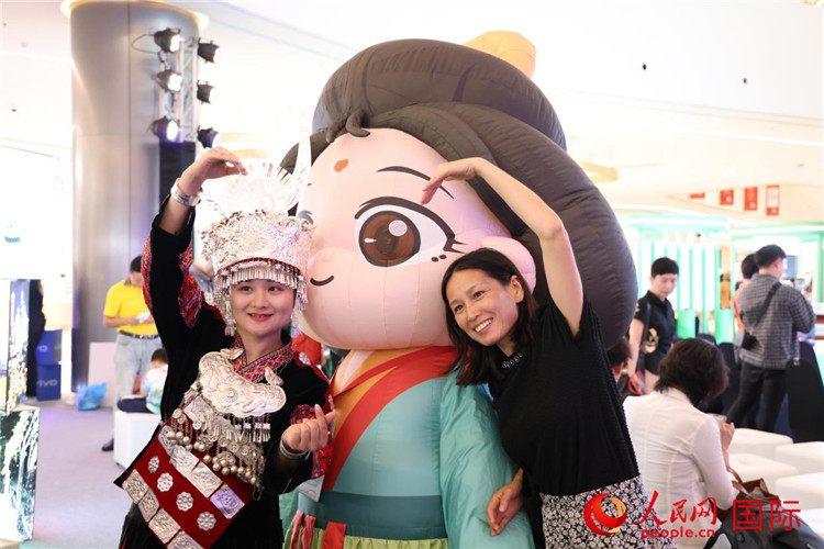 活動(dòng)現(xiàn)場(chǎng)，泰國(guó)民眾與身著少數(shù)民族服飾的重慶代表團(tuán)旅游推介人員合影。人民網(wǎng)記者 楊一攝