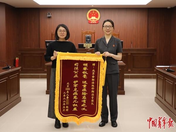 曾妮（左）给北京金融法院法官舒翔（右）送来锦旗。中青报·中青网记者 刘胤衡/摄