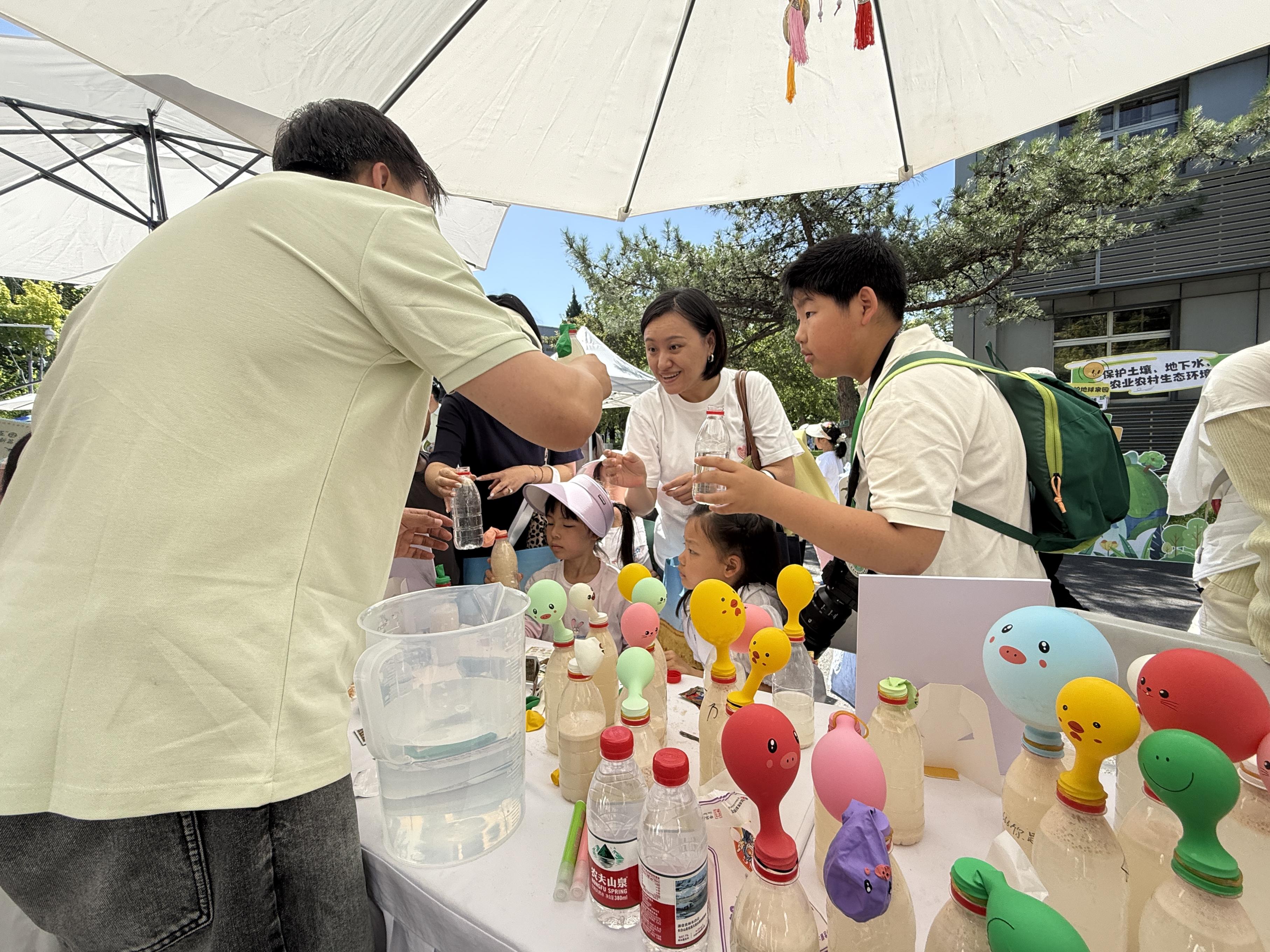 活动现场，家长带着孩子积极参与互动。人民网 欧阳易佳摄